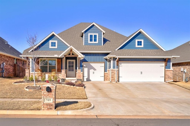 craftsman inspired home with driveway, a shingled roof, covered porch, board and batten siding, and brick siding