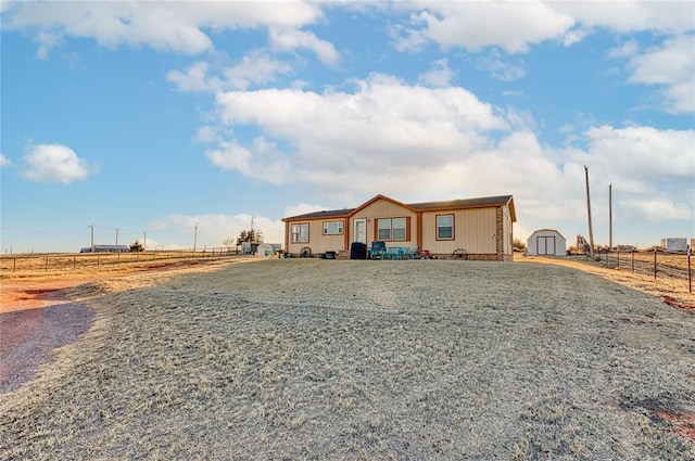 manufactured / mobile home with fence, a storage unit, and an outbuilding