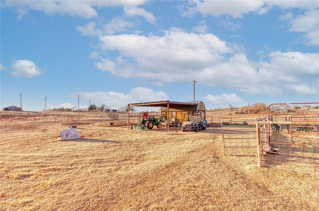 view of yard featuring a rural view, a pole building, fence, and an outdoor structure