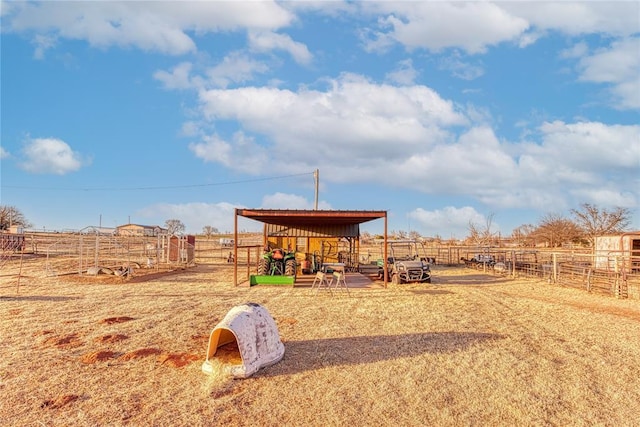 view of playground featuring an exterior structure, an outbuilding, and a rural view