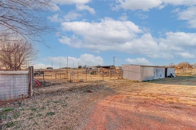 view of yard with a pole building, an outdoor structure, and fence