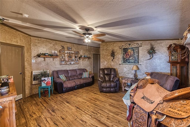 living room featuring a textured ceiling, ornamental molding, wood finished floors, and heating unit