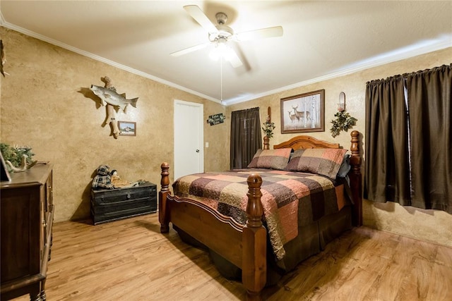 bedroom featuring light wood-type flooring, ornamental molding, and a ceiling fan