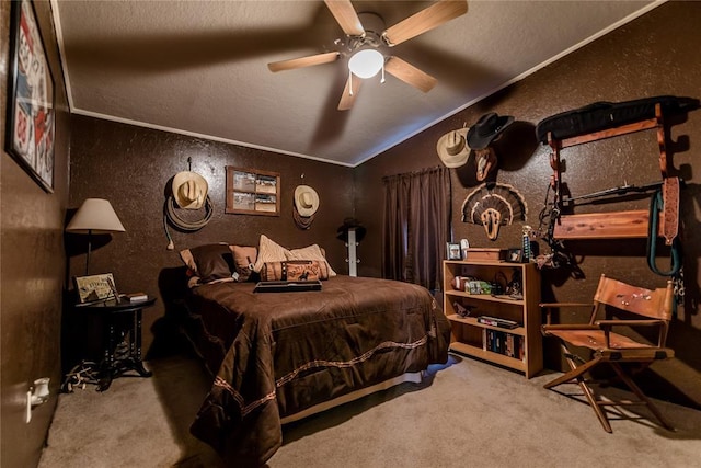 bedroom featuring ceiling fan, a textured wall, carpet floors, vaulted ceiling, and ornamental molding