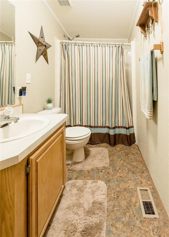 bathroom with ornamental molding, visible vents, and vanity