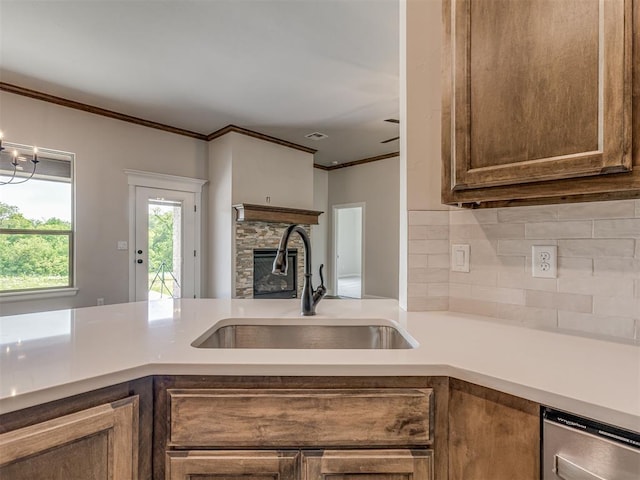 10124 Gentry Xing, Oklahoma City, OK 73169 - kitchen featuring backsplash, crown molding, a stone fireplace, light countertops, and dishwasher