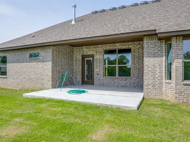 10124 Gentry Xing, Oklahoma City, OK 73169 - back of property with a patio, a shingled roof, a yard, and brick siding