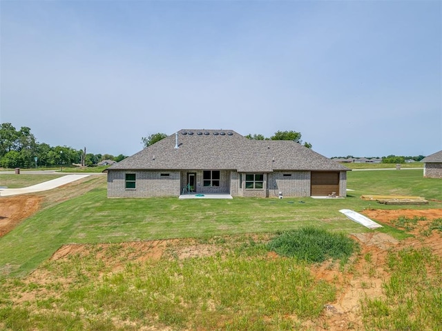 10124 Gentry Xing, Oklahoma City, OK 73169 - rear view of house featuring a garage, a lawn, and brick siding