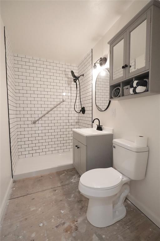 full bathroom featuring a stall shower, vanity, and toilet