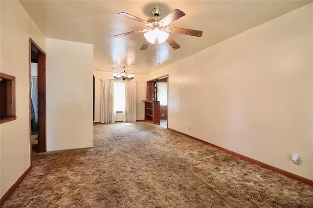 empty room featuring ceiling fan with notable chandelier, carpet flooring, and baseboards