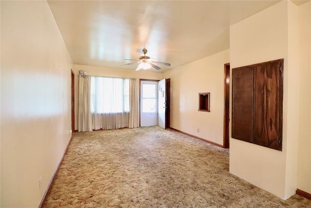 spare room with a ceiling fan, carpet flooring, and baseboards