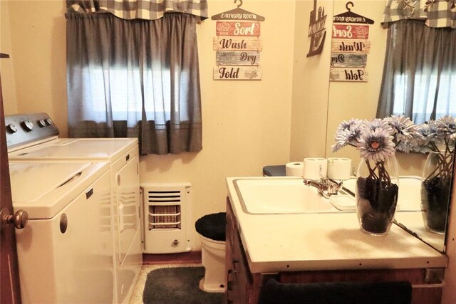 laundry room featuring washer and dryer, laundry area, a sink, and heating unit