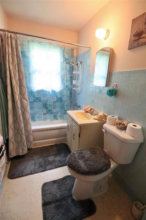 bathroom with vanity, tile walls, toilet, and shower / bath combo with shower curtain