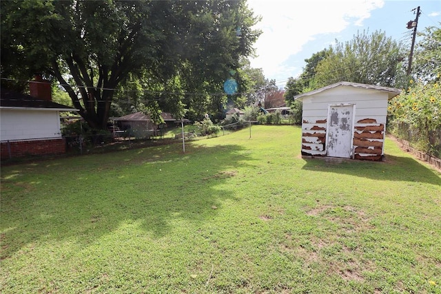 view of yard with a fenced backyard, an outdoor structure, and a storage shed