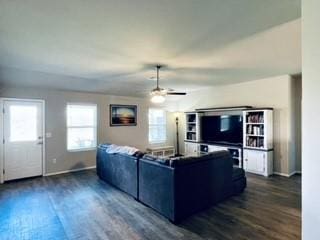 living area featuring dark wood-style floors, baseboards, and a ceiling fan