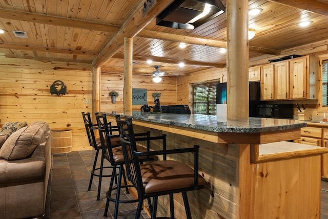 kitchen featuring beamed ceiling, wood walls, light brown cabinets, and wood ceiling