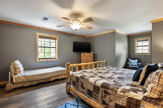 bedroom featuring crown molding, multiple windows, visible vents, and wood finished floors