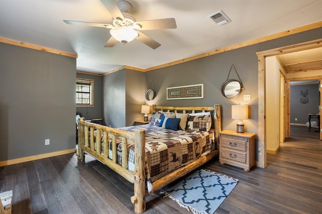 bedroom with dark wood-style floors, visible vents, ornamental molding, and baseboards