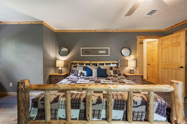 bedroom with ornamental molding, wood finished floors, visible vents, and baseboards