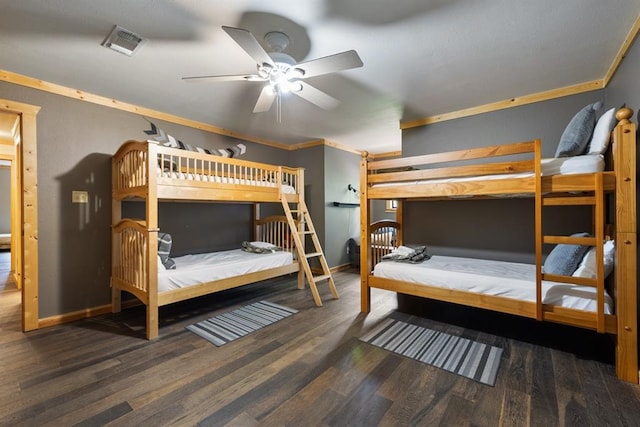 bedroom with visible vents, crown molding, baseboards, and wood finished floors