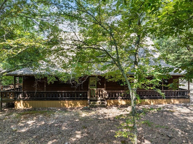 exterior space with covered porch and faux log siding