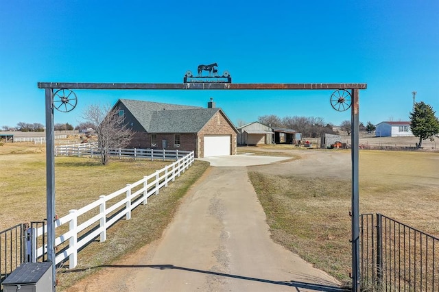 view of street featuring dirt driveway and a gated entry