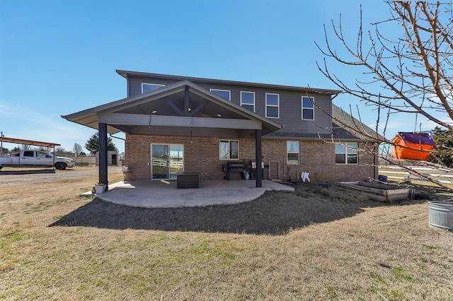 rear view of house featuring a patio area, brick siding, and a lawn