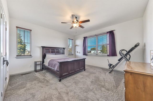 bedroom with light carpet, multiple windows, visible vents, and a ceiling fan