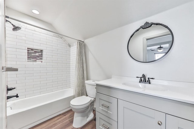 full bath with shower / bath combo, toilet, wood finished floors, vaulted ceiling, and vanity