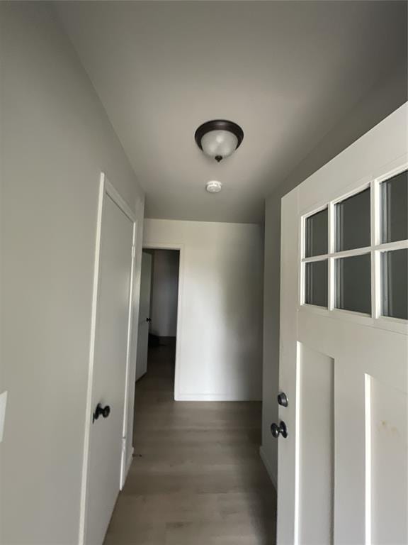 hallway featuring light wood-style flooring and baseboards