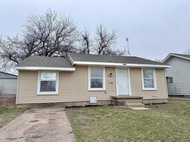 view of front facade with a front lawn and roof with shingles