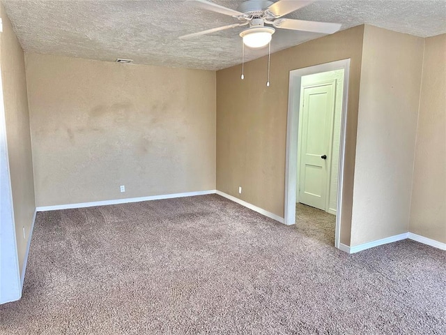 carpeted empty room featuring a ceiling fan, baseboards, and a textured ceiling