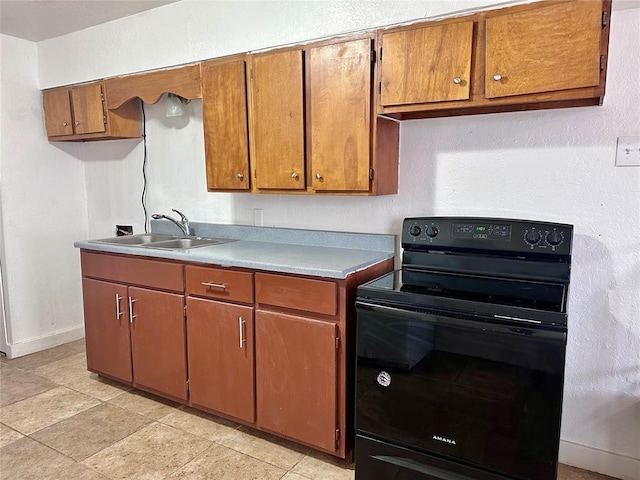 kitchen featuring electric range, a sink, and brown cabinets