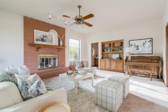 living area featuring light carpet, rail lighting, a fireplace, and a ceiling fan