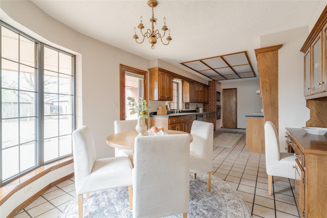 dining area with light tile patterned floors, plenty of natural light, and an inviting chandelier