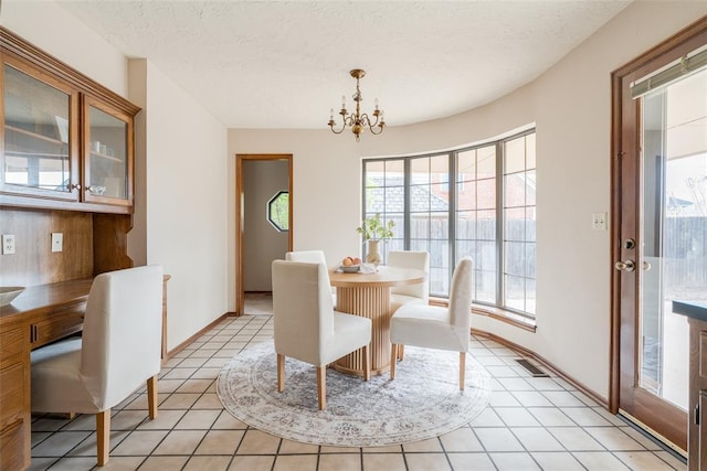 dining space featuring visible vents, baseboards, light tile patterned floors, a notable chandelier, and a textured ceiling