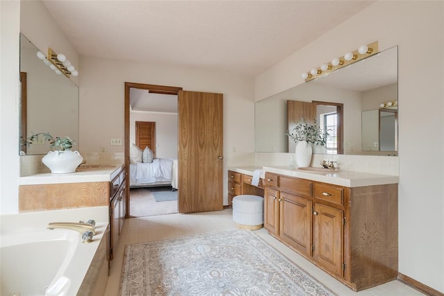 ensuite bathroom featuring ensuite bathroom, a bath, vanity, and tile patterned floors