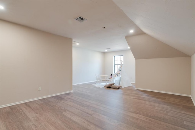 additional living space with visible vents, baseboards, recessed lighting, wood finished floors, and lofted ceiling