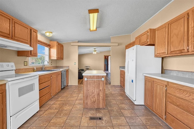 kitchen featuring white appliances, a kitchen island, a sink, visible vents, and light countertops