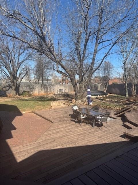 deck featuring outdoor dining area and a fenced backyard