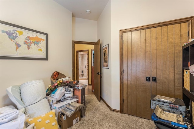 hallway featuring light carpet and baseboards