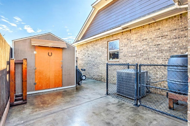 view of side of property featuring central air condition unit, brick siding, an outdoor structure, fence, and a shed