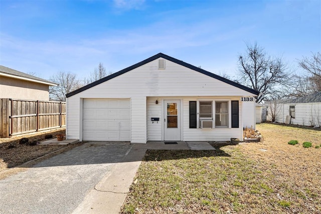 view of front facade with a front lawn, driveway, fence, cooling unit, and a garage