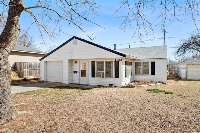 view of front of home featuring a garage, driveway, and fence