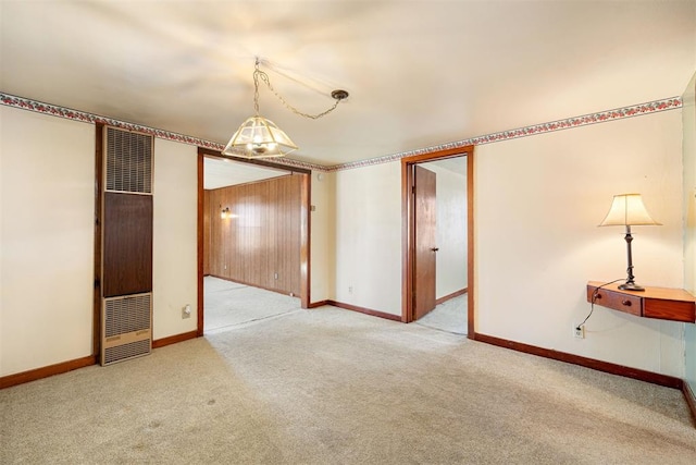 unfurnished room with a heating unit, baseboards, and carpet floors