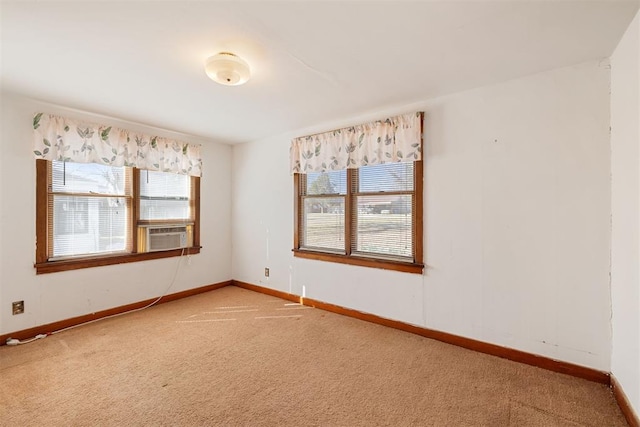 unfurnished room featuring a healthy amount of sunlight, light colored carpet, and baseboards