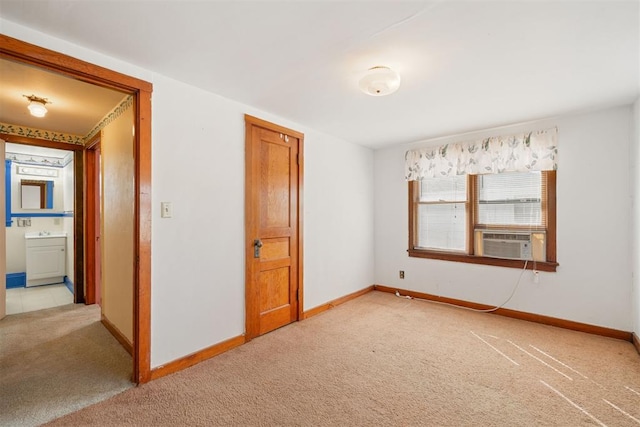 interior space featuring cooling unit, baseboards, and light carpet