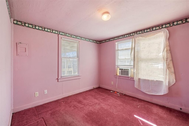 carpeted spare room featuring cooling unit and baseboards