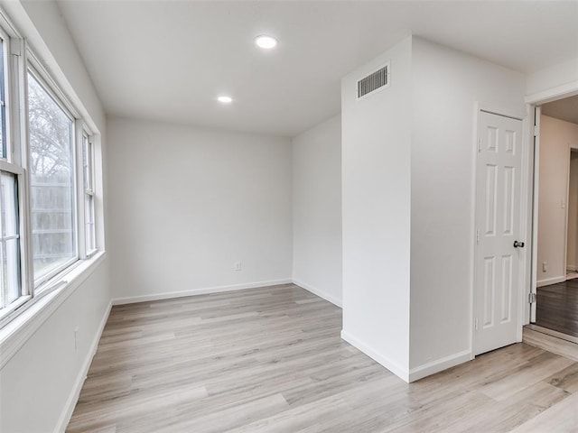 spare room with light wood-style floors, recessed lighting, visible vents, and baseboards