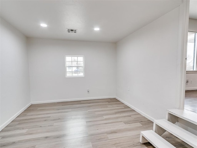 spare room featuring recessed lighting, light wood-type flooring, visible vents, and baseboards